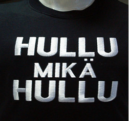 Valokuva mustalle kankaalle brodeeratun paidan rintamuksesta. Brodeerauksessa lukee paksuin valkoisin kirjaimin, että "Hullu mikä hullu".